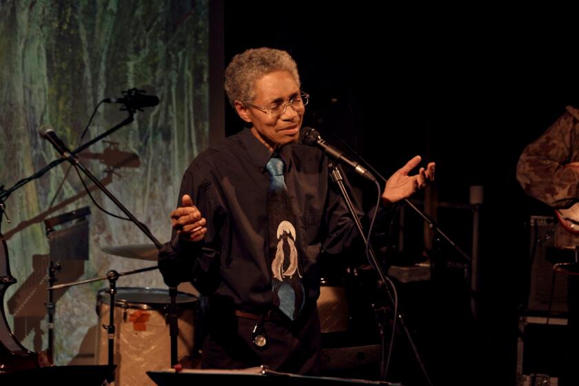 A musician at a microphone holds his hands out in the documentary "Keyboard Fantasies."