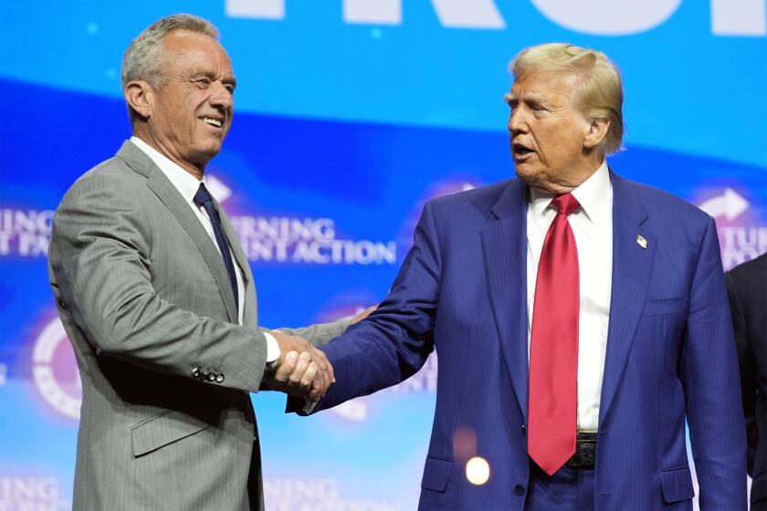 El candidato presidencial republicano, el expresidente Donald Trump, estrecha la mano de Robert F. Kennedy Jr. en un mitin de la campaña Turning Point Action, el miércoles 23 de octubre de 2024, en Duluth, Georgia (Foto AP/Alex Brandon)