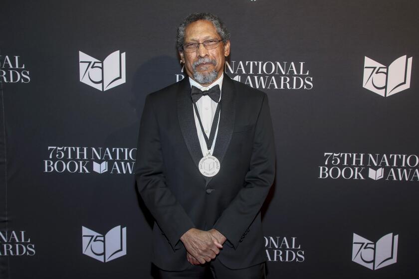 L.A. author Percival Everett poses in a black suit, with a medal, at the 2024 National Book Awards ceremony in New York