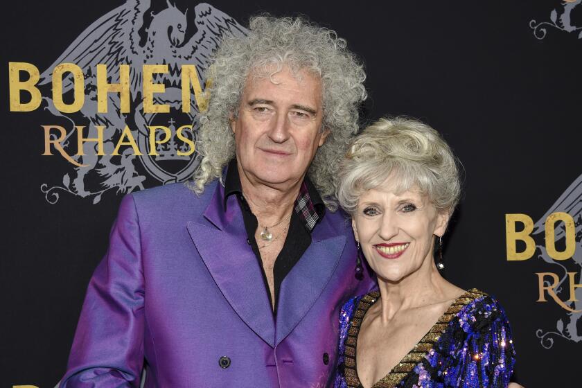 Brian May poses with his arm around his wife, actor Anita Dobson, at a movie preimiere