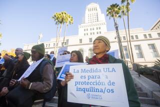 Los Angeles, CA - December 10: DJ Yoon of Koreatown Immigrants Workers Alliance, holding a sign stands a press conference about how Measure ULA (the Mansion Tax) funds will be used to promote affordable housing, tenant protections, at City Hall Tuesday, Dec. 10, 2024 in Los Angeles, CA. (Ringo Chiu / For The Times)