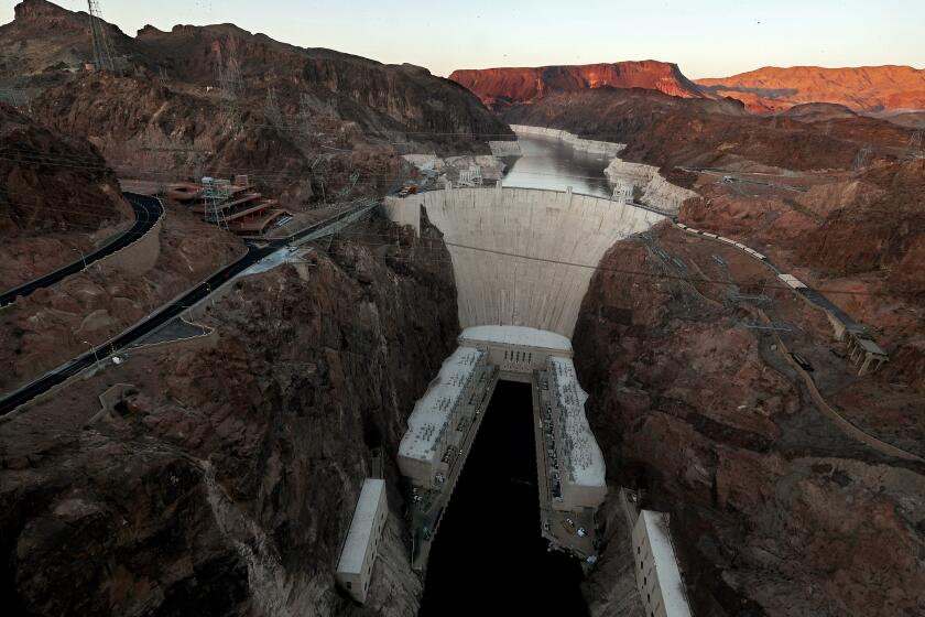 BOULDER CITY, NEV. - MAY 16, 2022. The Hoover Dam stands in front of Lake Mead, where white surfaces on the lake's rocky edges show how low water levels have dropped due to persistent and worsening drought conditions for more than a decade. With a current level of about 1,055 feet, Lake Mead is at its lowest point in history even as its continues to supply water to more than 20 people in the lower basin of the Colorado River. With little snowmelt and rain flowing into the lake, the historic dam's hydroelectric generating machinery could become obsolete. (Luis Sinco / Los Angeles Times)