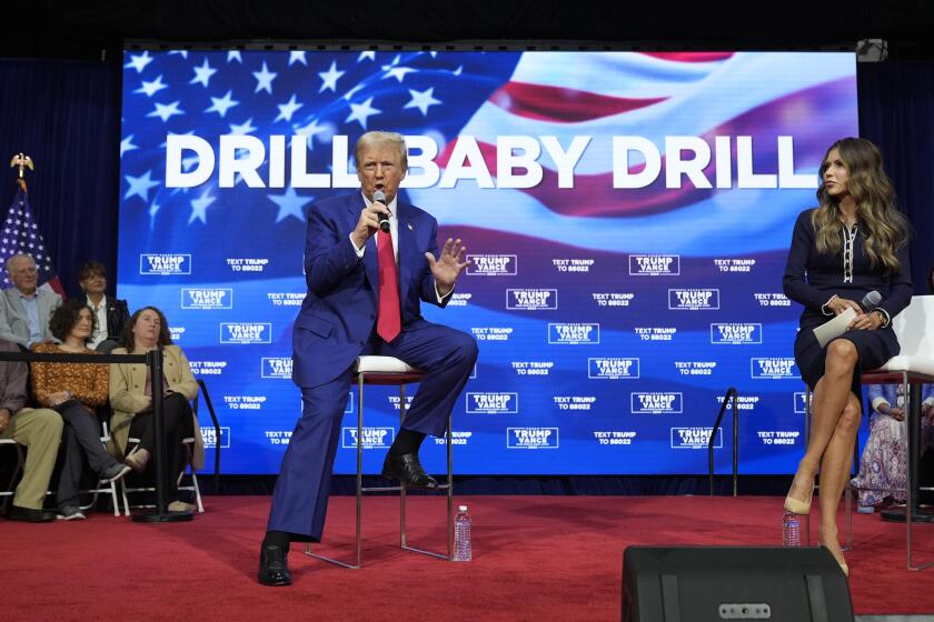 FILE - Republican presidential nominee former President Donald Trump speaks at a campaign town hall at the Greater Philadelphia Expo Center & Fairgrounds, Oct. 14, 2024, in Oaks, Pa., as moderator South Dakota Gov. Kristi Noem listens. (AP Photo/Alex Brandon)