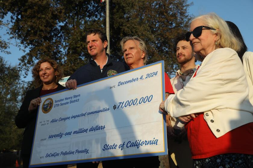 CHATSWORTH, CA - DECEMBER 4, 2024 - - California Assemblymember Pilar Schiavo, from left, California Senator Henry Stern, Matt Pecucko, with Save Porter Ranch, Amadeo Feingold, with Climate Resolve and Patty Glueck, right, with Aliso Moms Alliance, hold a $71 million settlement check presented to members of the communities effected by the Alison Canyon Well Failure in front of the Southern California Gas Company in Chatsworth on December 4, 2024. The settlement was due to the Alison Canyon Well Failure in 2015-2015. The disaster spewed about 100,000 tons of methane and other chemicals into the air, forcing more than 8,000 families to flee their homes, with many reporting headaches, nosebleeds and nausea. (Genaro Molina/Los Angeles Times)