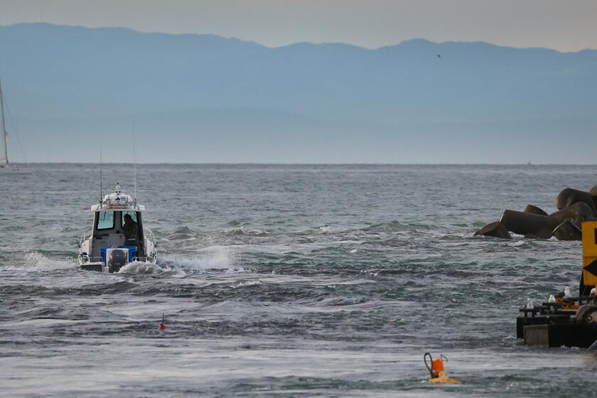 SANTA CRUZ CA JANUARY 15, 2022 - A boat slices through tsunami surge at the mouth of the Santa Cruz Small Craft Harbor and heads out to the relative safety of the open water on Saturday. (Shmuel Thaler/Santa Cruz Sentinel)