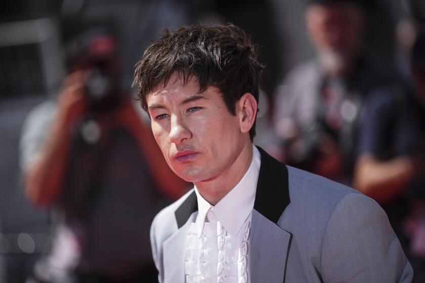 Barry Keoghan poses for photographers at a film premiere wearing a blue suit