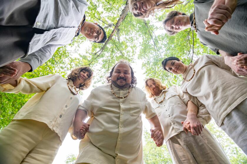 Cult members make a circle in a field.