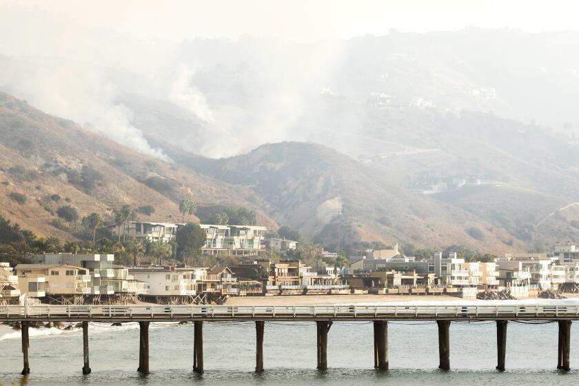 MALIBU, CA - DECEMBER 10: Smoke rises from the Franklin fire in the hills near the Malibu Pier on Tuesday, Dec. 10, 2024. (Myung J. Chun / Los Angeles Times)